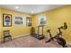 Workout room with exercise bike and treadmill, bright yellow walls, and lots of natural light from two windows at 4232 Spring Ln, Lakeland, FL 33811