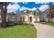 Inviting single-story home with landscaped lawn, charming arched windows, and a well-maintained exterior at 428 Orista Dr, Davenport, FL 33897