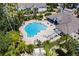Aerial shot of the community pool featuring a spacious lounge area, hot tub, and surrounding lush landscaping at 4340 S Kirkman Rd # 901, Orlando, FL 32811