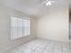 Bright bedroom with white tile flooring, a ceiling fan, and a large window at 50989 Highway 27 # 174, Davenport, FL 33897