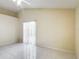 Neutral bedroom featuring white tile flooring, ceiling fan, and a sliding glass door to the backyard at 50989 Highway 27 # 174, Davenport, FL 33897