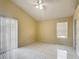 Bright room with a ceiling fan, white tile flooring, and a sliding glass door at 50989 Highway 27 # 174, Davenport, FL 33897