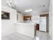 Eat-in kitchen with classic cabinets, white appliances, and tile flooring at 50989 Highway 27 # 174, Davenport, FL 33897