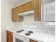 Bright kitchen with wood cabinets, a white range, and a view from the window at 50989 Highway 27 # 174, Davenport, FL 33897