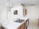 Open kitchen with double sink, wood cabinetry, and a view to dining area at 50989 Highway 27 # 174, Davenport, FL 33897