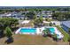 Aerial view of a community pool with plenty of lounge chairs and palm trees at 50989 Highway 27 # 174, Davenport, FL 33897