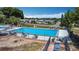 An aerial view showcases the community pool with lounge chairs, set amongst homes and lush trees at 50989 Highway 27 # 174, Davenport, FL 33897