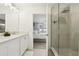 Bright bathroom showcasing double sinks, shower, and bedroom access at 646 Longboat Dr, Davenport, FL 33896