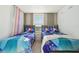 A well-lit ' room with two beds, themed bedding and curtains, and neutral walls at 646 Longboat Dr, Davenport, FL 33896