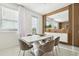 Bright dining area features a modern white table, stylish chairs, and a decorative wood accent wall with built-in mirror at 646 Longboat Dr, Davenport, FL 33896
