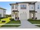 Charming townhouse with a well-maintained lawn, a private garage and walkway leading to the front door at 646 Longboat Dr, Davenport, FL 33896