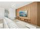 Comfortable living room featuring a plush sofa, a large TV mounted on a wood accent wall, and contemporary lighting at 646 Longboat Dr, Davenport, FL 33896