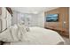 Bright primary bedroom with a bed facing a wood accent wall with mounted TV at 646 Longboat Dr, Davenport, FL 33896
