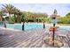 Community pool area surrounded by lounge chairs and decorative sign post at 646 Longboat Dr, Davenport, FL 33896