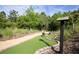 Meandering putting green with mature landscaping, brick border, and wooden decorations on the path at 646 Longboat Dr, Davenport, FL 33896