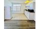 A bright kitchen area with white cabinets and appliances, and contrasting tile and wood-look flooring at 658 Caribbean Dr, Davenport, FL 33897