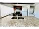 Granite countertops and stainless steel appliances, with dark wood cabinets and view to a laundry closet at 658 Caribbean Dr, Davenport, FL 33897