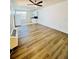 Open living area featuring wood-look flooring, ceiling fan, and view into the bright kitchen at 658 Caribbean Dr, Davenport, FL 33897