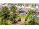 An aerial view showcases a home with screened pool and landscaped backyard at 715 Troon Cir, Davenport, FL 33897