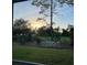 Scenic backyard with a hammock, patio furniture and view of the trees and the setting sun at 715 Troon Cir, Davenport, FL 33897