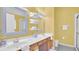 Bright bathroom featuring a double vanity with wooden cabinets and a large framed mirror at 715 Troon Cir, Davenport, FL 33897