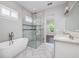 Elegant bathroom featuring a soaking tub and a glass-enclosed shower with stylish tile accents at 795 W Canton Ave, Winter Park, FL 32789
