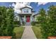 Charming two-story home with a brick pathway leading to a red front door and landscaped front yard at 795 W Canton Ave, Winter Park, FL 32789