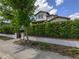 A two-story home with a privacy hedge and a walkway with an iron gate, providing an inviting approach at 795 W Canton Ave, Winter Park, FL 32789
