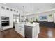 Bright, white kitchen with stainless steel appliances, farmhouse sink, granite countertops, and an island overlooking the living room at 795 W Canton Ave, Winter Park, FL 32789