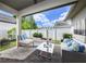 Relaxing covered patio with brick flooring, comfortable seating, a fire pit, and views of the fenced backyard at 795 W Canton Ave, Winter Park, FL 32789