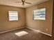 This is a bedroom with tan colored walls and carpeting. The room has two windows and a ceiling fan at 804 Little Wekiwa Dr, Altamonte Springs, FL 32714