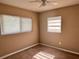 This is a bedroom with tan colored walls and carpeting. The room has two windows and a ceiling fan at 804 Little Wekiwa Dr, Altamonte Springs, FL 32714