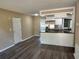 Open-concept living area with wood floors connecting to the kitchen and featuring a neutral color palette at 804 Little Wekiwa Dr, Altamonte Springs, FL 32714