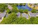 An aerial view of the property featuring a pool, waterfront views, and lush surrounding foliage at 8440 Woburn Ct, Windermere, FL 34786