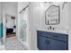 Bright bathroom featuring a blue vanity cabinet, quartz countertop, and a walk-in glass shower at 8440 Woburn Ct, Windermere, FL 34786
