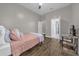 Bedroom featuring wood floors, a gray bed with pink comforter, and a desk with a TV at 8440 Woburn Ct, Windermere, FL 34786