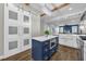 Bright kitchen featuring a blue island, farmhouse sink, and white cabinetry at 8440 Woburn Ct, Windermere, FL 34786