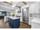 Bright open kitchen with stainless steel appliances, a blue island and wooden beams at 8440 Woburn Ct, Windermere, FL 34786