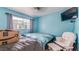 Cozy bedroom showcasing blue walls, carpeted floors, and a comforting seating area with natural lighting at 8606 Lsu Ln, Orlando, FL 32817