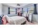Comfortable bedroom features two windows with natural lighting, ceiling fan, and decorative elements at 8606 Lsu Ln, Orlando, FL 32817