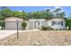 Inviting one-story home featuring symmetrical design, mature trees, and a well-manicured lawn enhancing curb appeal at 8606 Lsu Ln, Orlando, FL 32817