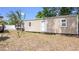 Backyard shed with adjacent empty lot, resting on blocks, and featuring two windows and a door at 8606 Lsu Ln, Orlando, FL 32817