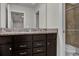 Bathroom featuring double vanity with granite countertops and a tiled walk-in shower at 8814 Geneve Ct, Kissimmee, FL 34747
