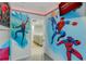 Spiderman themed bedroom featuring custom wall art and a doorway to another themed room at 8814 Geneve Ct, Kissimmee, FL 34747