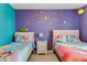 A bedroom with twin beds, princess-themed bedding, and star decals on the purple wall at 8814 Geneve Ct, Kissimmee, FL 34747