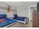 Bright bedroom showcasing two twin beds with themed bedding and decor, next to dresser and door at 8814 Geneve Ct, Kissimmee, FL 34747