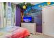 A bedroom features a mural, themed decor, and natural light from the window at 8814 Geneve Ct, Kissimmee, FL 34747