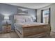 Cozy bedroom features a wooden bed frame, neutral bedding, and natural light at 8814 Geneve Ct, Kissimmee, FL 34747