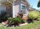Landscaped flower bed in front of the home features various plants and colorful purple flowers at 9313 Pavillion Dr, Orlando, FL 32825