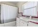 Vintage bathroom featuring colorful tiles, white cabinets, and shower with curtain at 932 Campbell Ave, Lake Wales, FL 33853